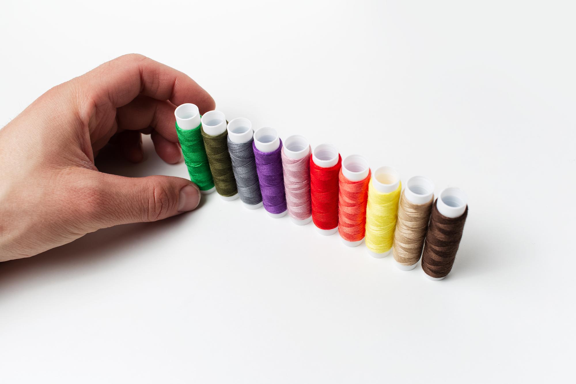 hands selecting threads for embroidery